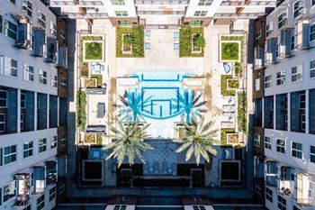 an aerial view of a building with a pool in the middle